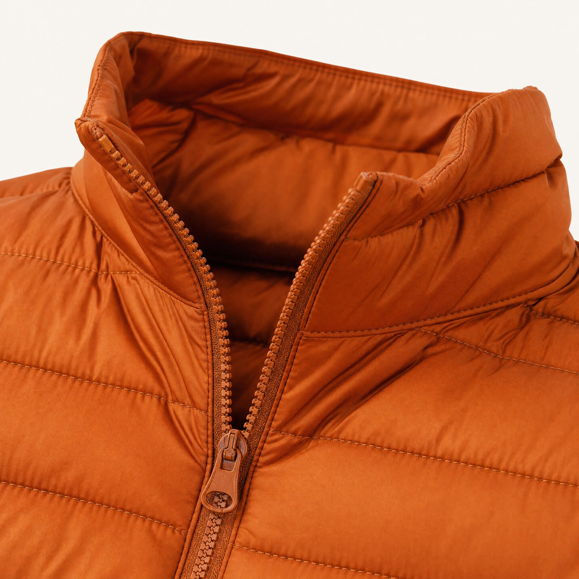 The Treeline Men's Quilted Puffer Jacket in Burnt Orange, detail close-up