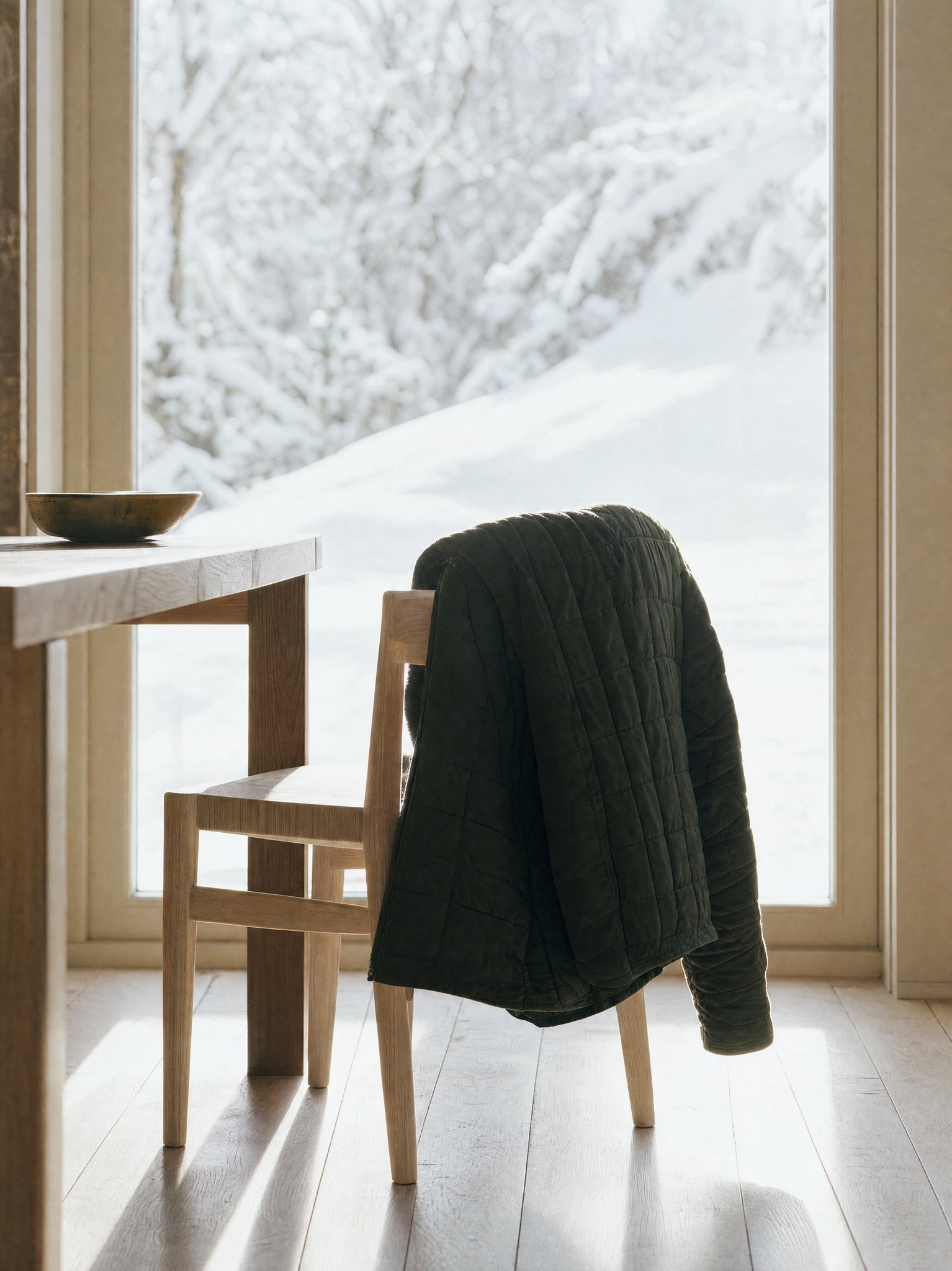 A heavy coat hanging on a single hook by a door